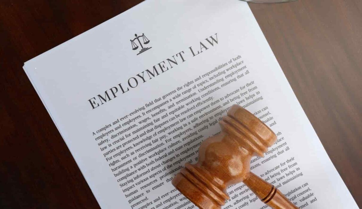 Employment Law consultation with a lawyer reviewing workplace contracts and employee rights documents in a professional office.