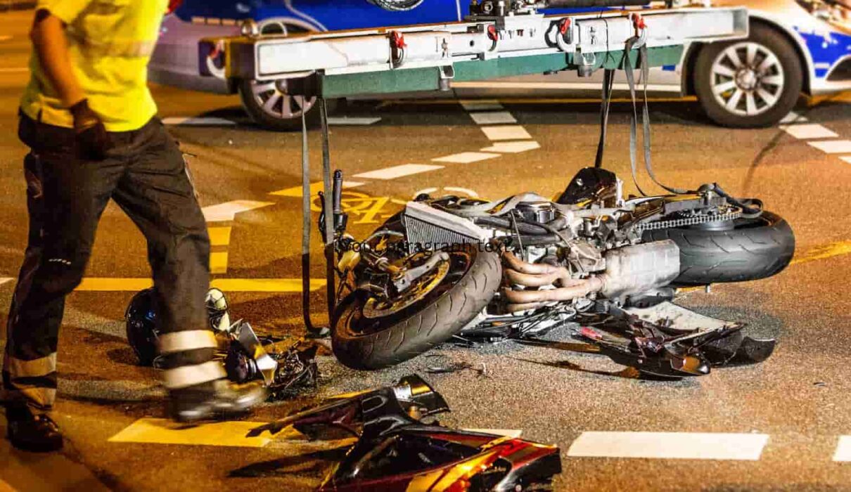 Motorcycle Accident Injuries after a serious road crash, showing a damaged motorcycle and emergency responders assisting an injured rider.