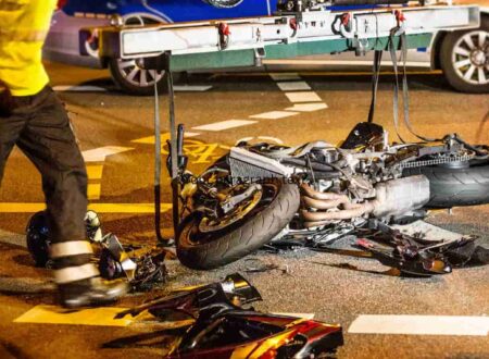 Motorcycle Accident Injuries after a serious road crash, showing a damaged motorcycle and emergency responders assisting an injured rider.
