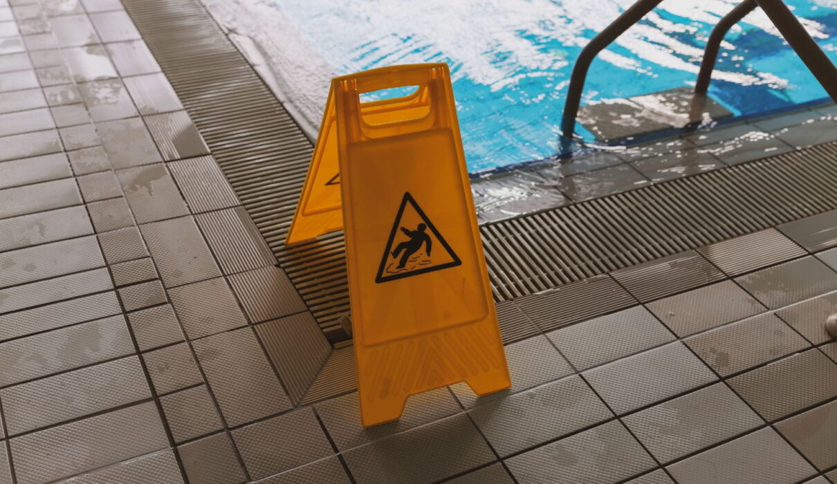 Person slipping on a wet floor while a lawyer reviews documents related to a slip and fall lawsuit and personal injury claim.
