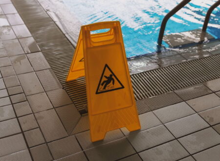 Person slipping on a wet floor while a lawyer reviews documents related to a slip and fall lawsuit and personal injury claim.