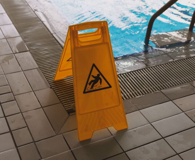 Person slipping on a wet floor while a lawyer reviews documents related to a slip and fall lawsuit and personal injury claim.