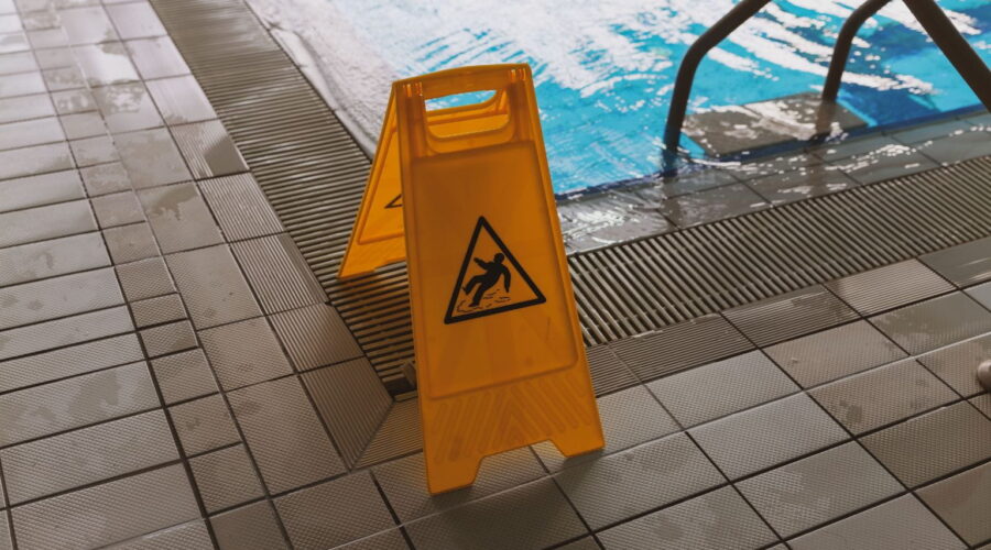 Person slipping on a wet floor while a lawyer reviews documents related to a slip and fall lawsuit and personal injury claim.