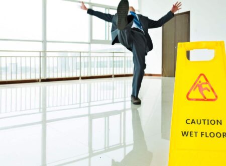 Person experiencing a Slip and Fall Accident on a wet floor in a public building, illustrating a common premises liability incident.