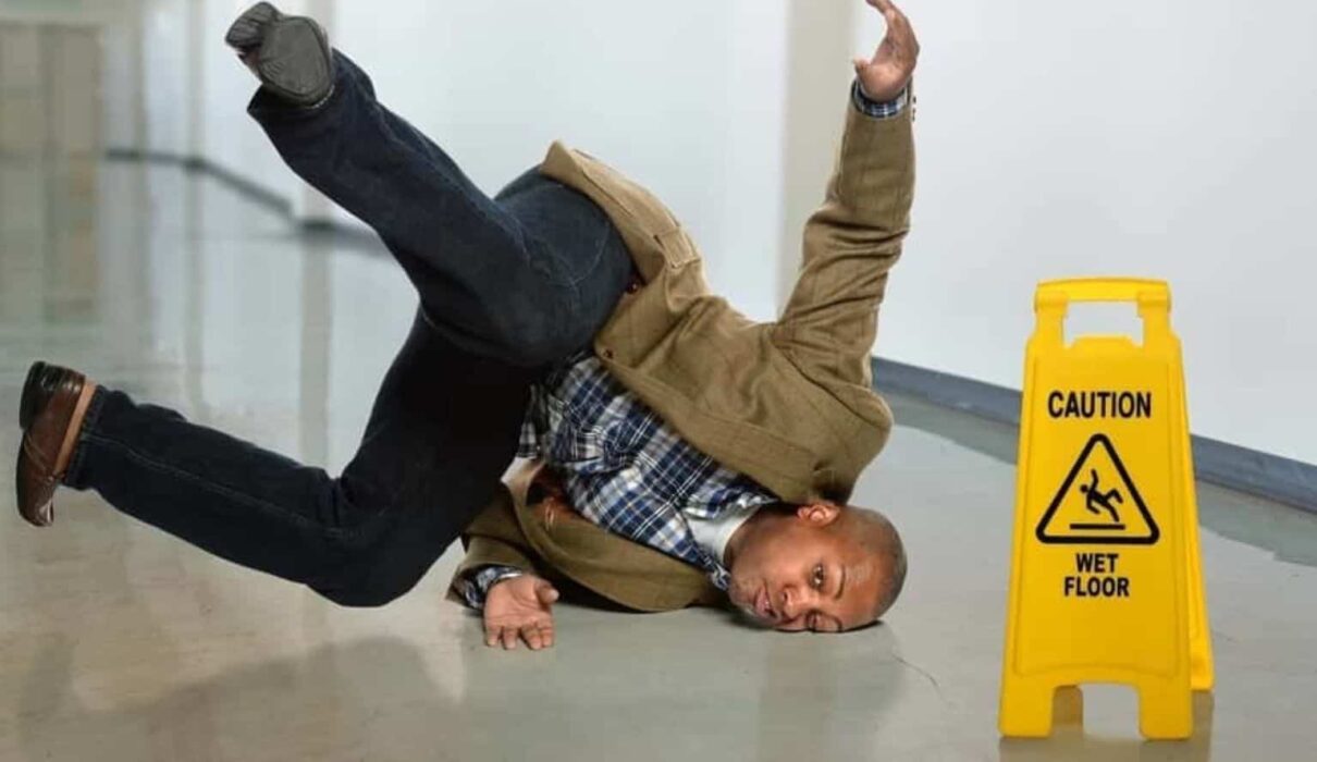 Person slipping on a wet floor in a public building, illustrating common causes of Slip and Fall Accidents.