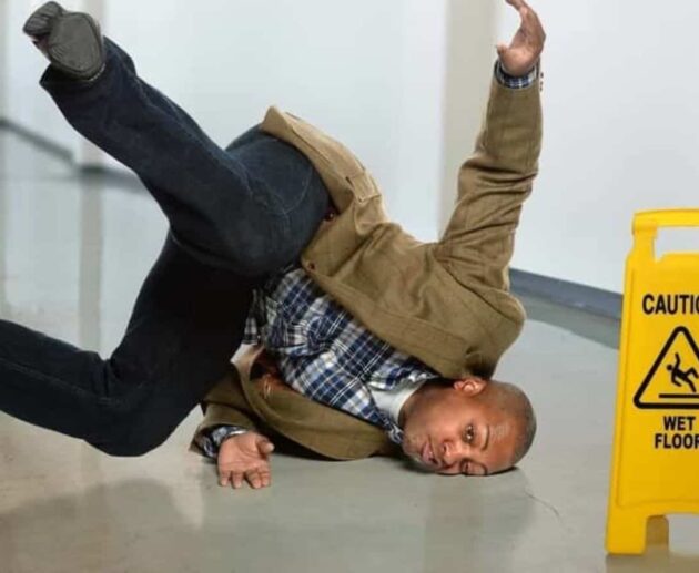 Person slipping on a wet floor in a public building, illustrating common causes of Slip and Fall Accidents.