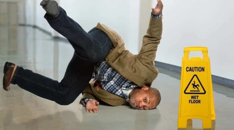 Person slipping on a wet floor in a public building, illustrating common causes of Slip and Fall Accidents.