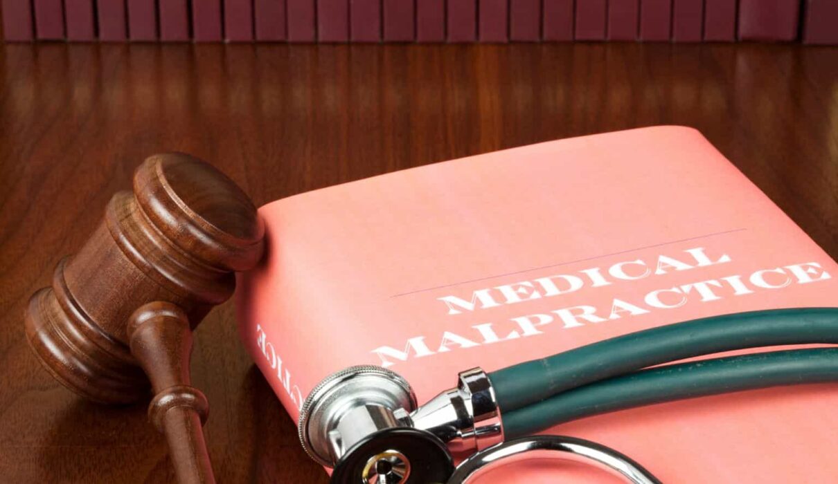Medical Malpractice Lawsuit consultation between a patient and an attorney reviewing medical records and legal documents related to a healthcare negligence claim.