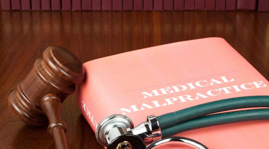 Medical Malpractice Lawsuit consultation between a patient and an attorney reviewing medical records and legal documents related to a healthcare negligence claim.