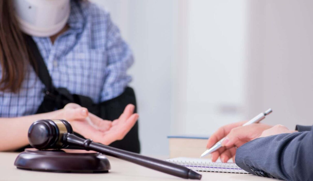 Personal Injury Lawsuit attorney consulting with an injured client while reviewing legal documents and evidence after an accident.