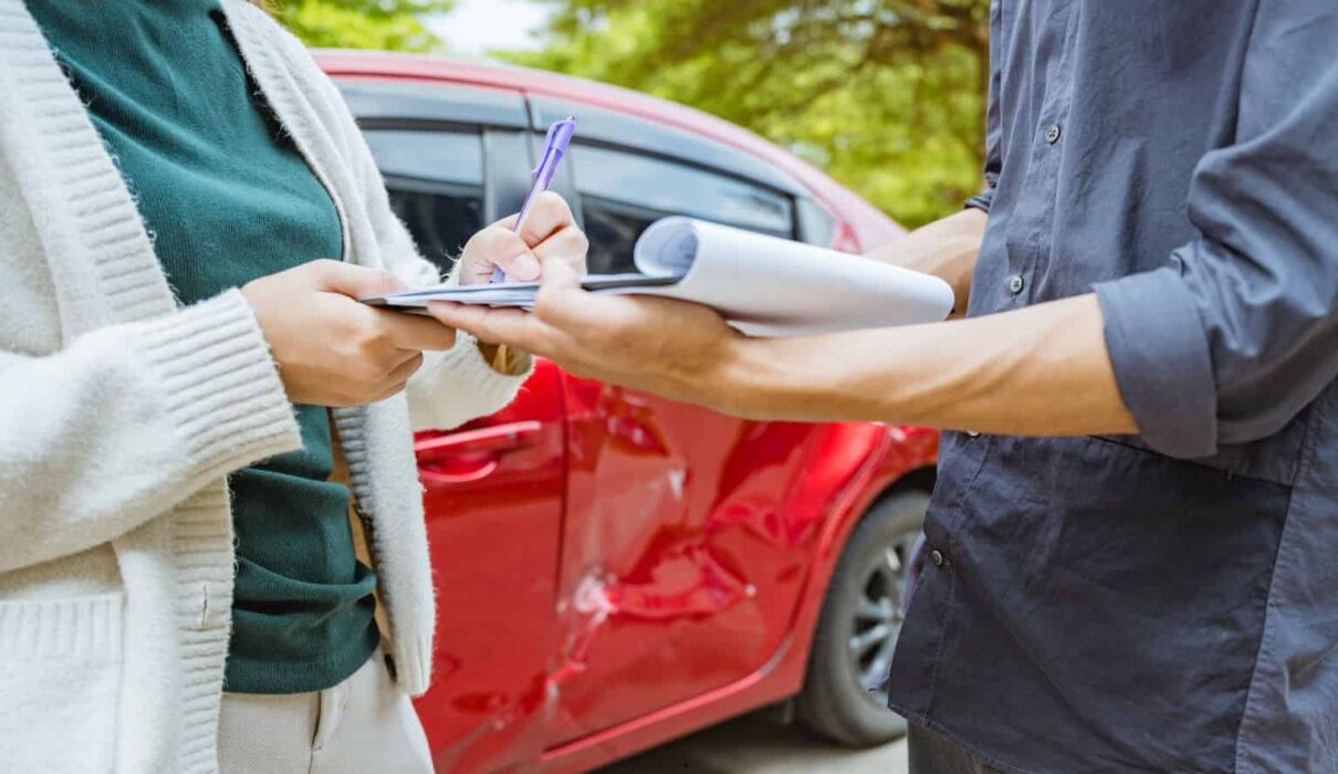 Rideshare Accident Claim involving a damaged rideshare vehicle after a traffic collision, with a passenger reviewing insurance and legal documents.
