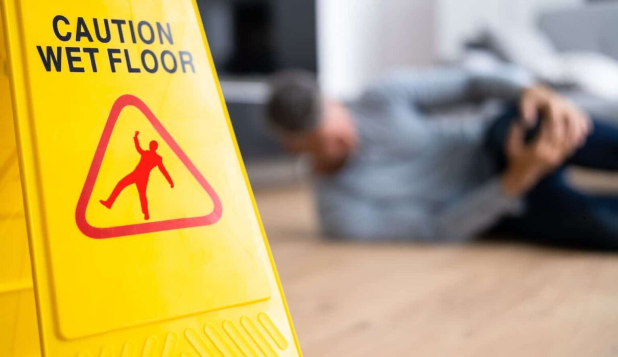 Person slipping on a wet floor in a public building, illustrating common Slip and Fall Accidents that can lead to serious injuries and legal claims.
