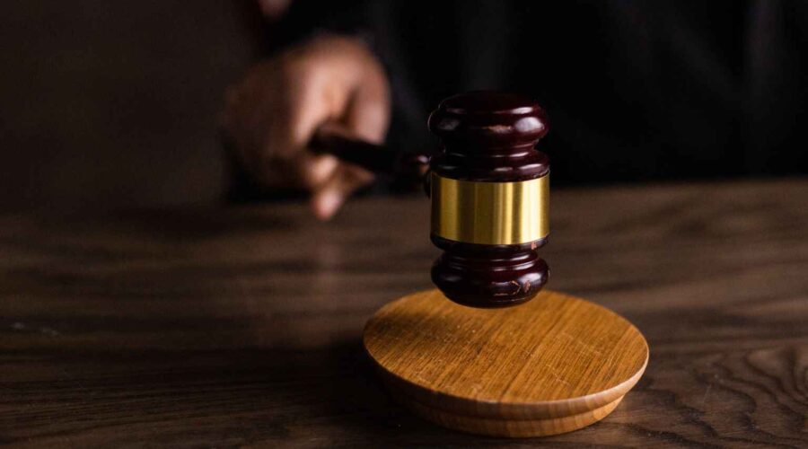 Illustration of a courthouse, justice scales, and federal grant documents representing the DOJ Grant Cancellations Lawsuit over canceled federal funding.
