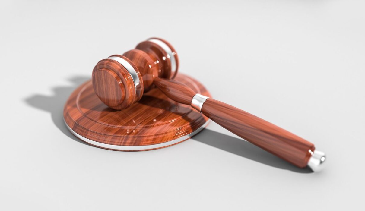 Illustration of a damaged vehicle, legal documents, and a judge's gavel representing the CarGuard lawsuit and consumer legal claims.