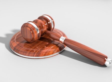 Illustration of a damaged vehicle, legal documents, and a judge's gavel representing the CarGuard lawsuit and consumer legal claims.