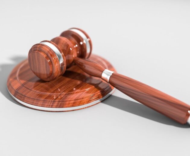 Illustration of a damaged vehicle, legal documents, and a judge's gavel representing the CarGuard lawsuit and consumer legal claims.