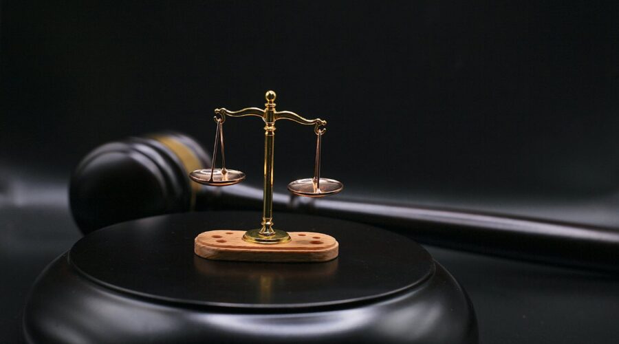 Gavel and scales of justice beside a blockchain network graphic, representing the OtterSec lawsuit over the crypto auditing firm's dissolution.