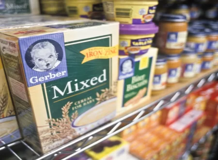 Illustration of a magnifying glass over a batch code on a baby snack box beside a recall alert icon