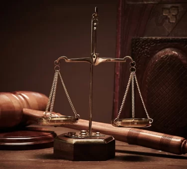 Illustration of scales of justice beside a Manhattan courthouse skyline for an article on Karen Friedman Agnifilo
